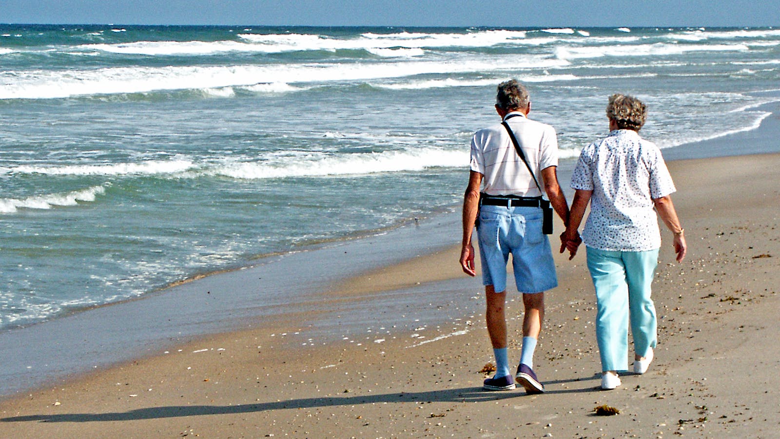 Florida senior couple walking on the beach, representing Medicare beneficiaries adjusting to 2026 program changes