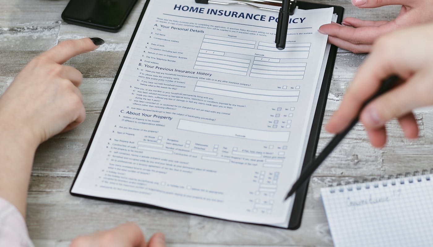 Florida bilingual Medicare agent reviewing 2027 plan options with a senior couple at a desk during a Medicare planning meeting