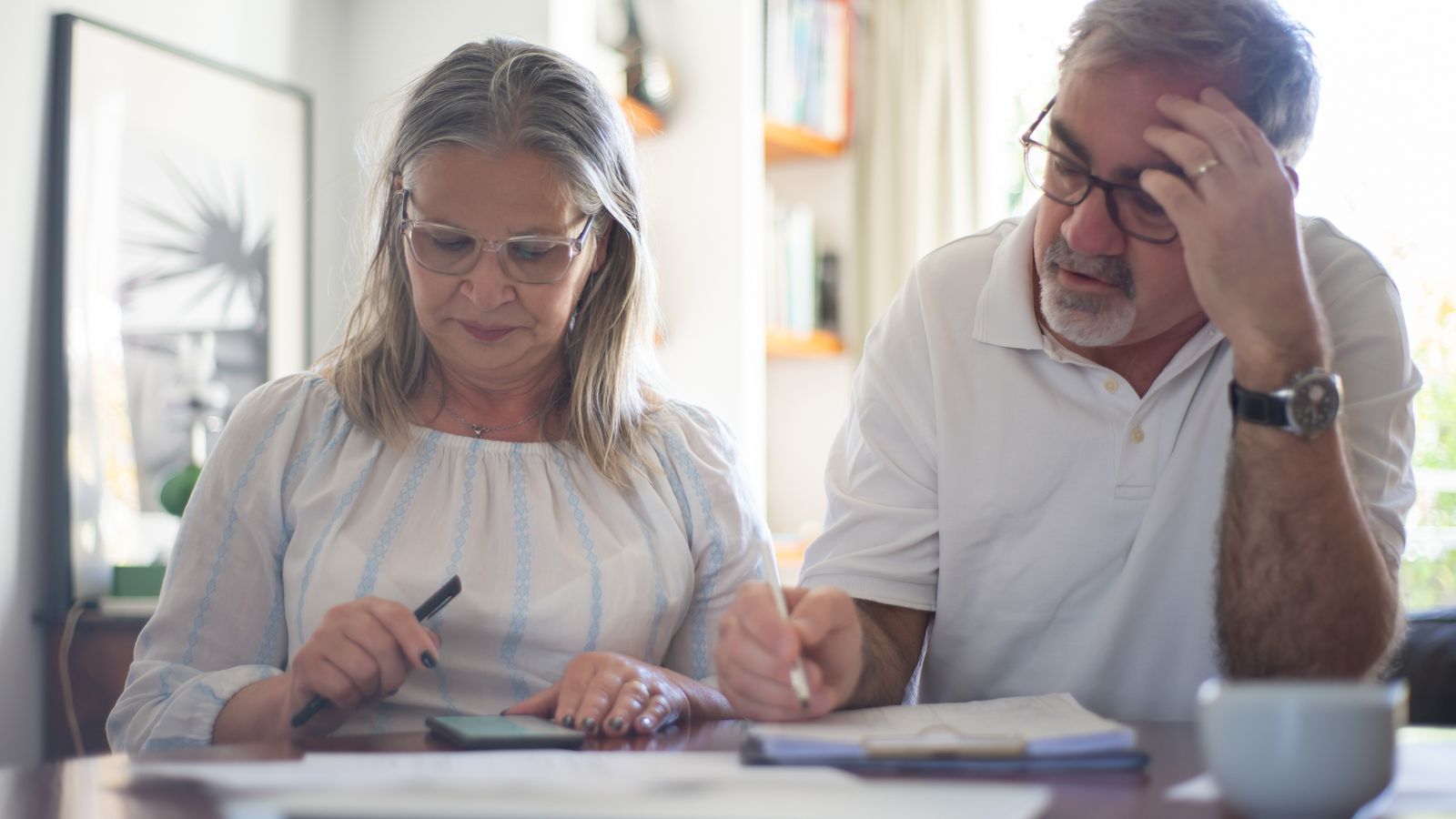 Florida senior couple reviewing income documents at a home desk, calculating MAGI for their 2026 Medicare IRMAA surcharge