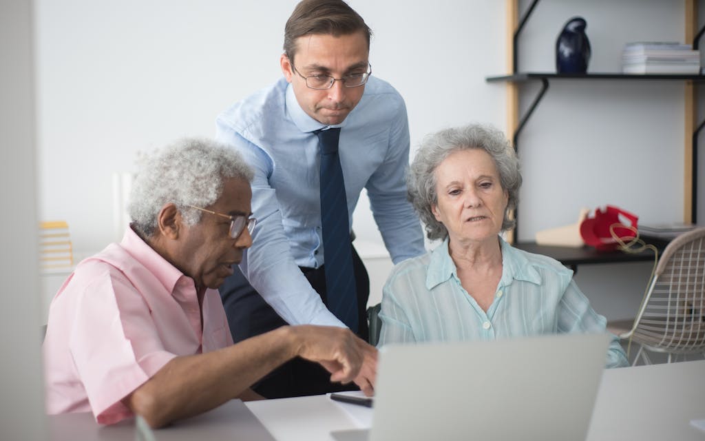 Pareja de adultos mayores revisando opciones de Medicare con una agente de seguros bilingüe en Florida